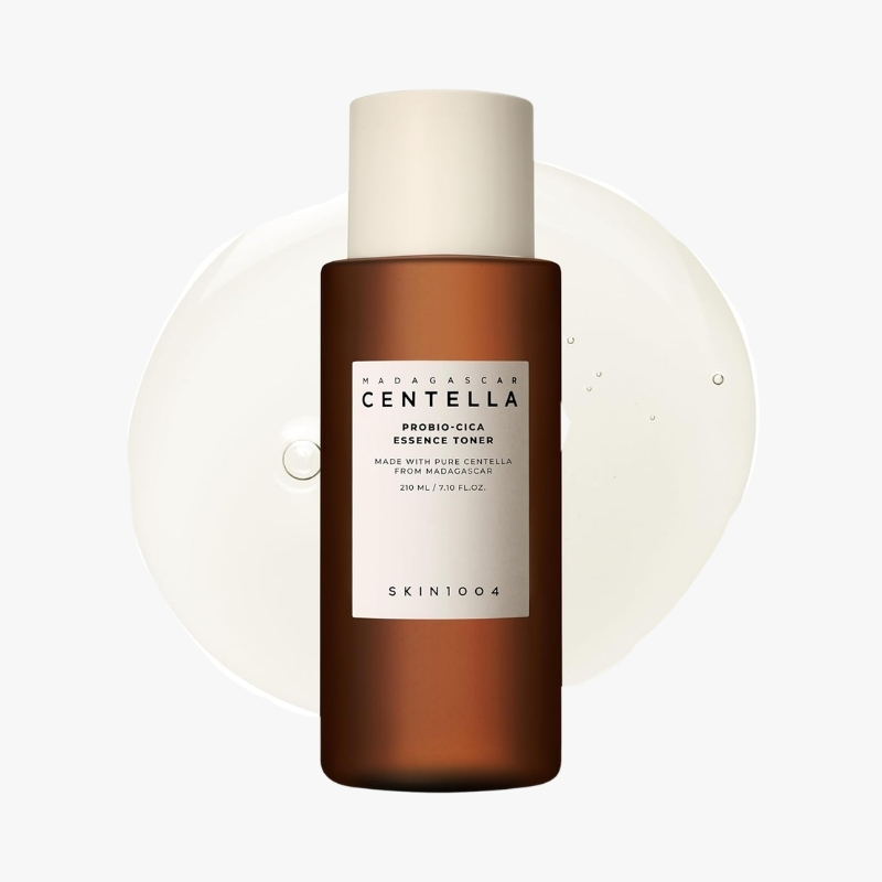 Centella Probio-Cica Essence Toner in a brown bottle with beige cap, labeled SKIN1004, against a light background.