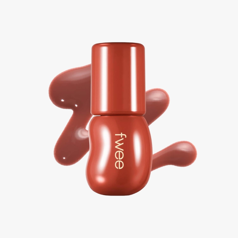 Red nail polish bottle with glossy red polish splashed behind it.