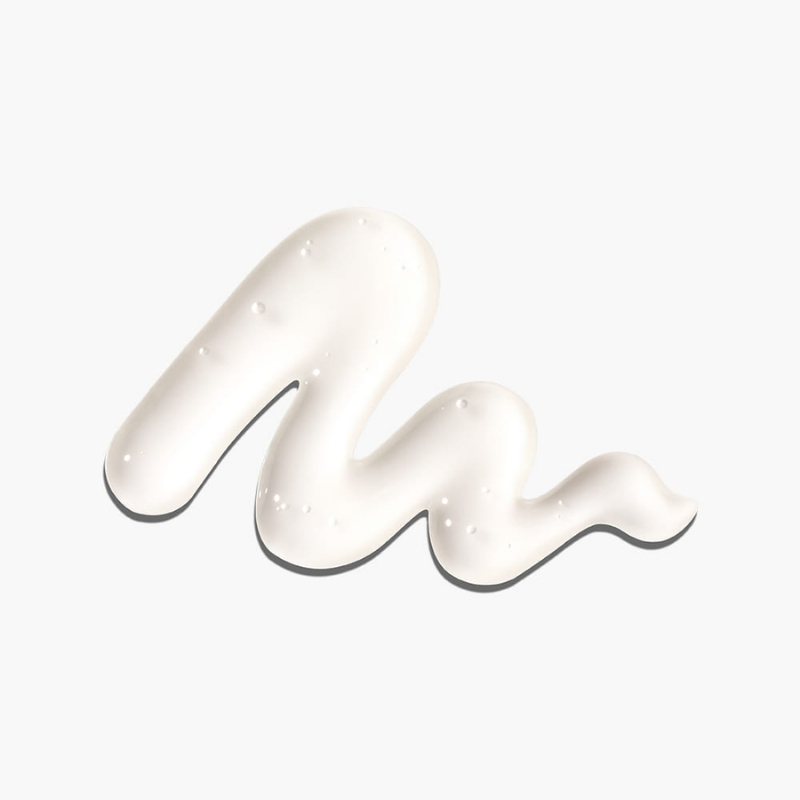 A smooth white cream swirl spread on a white background forming a curvy shape.