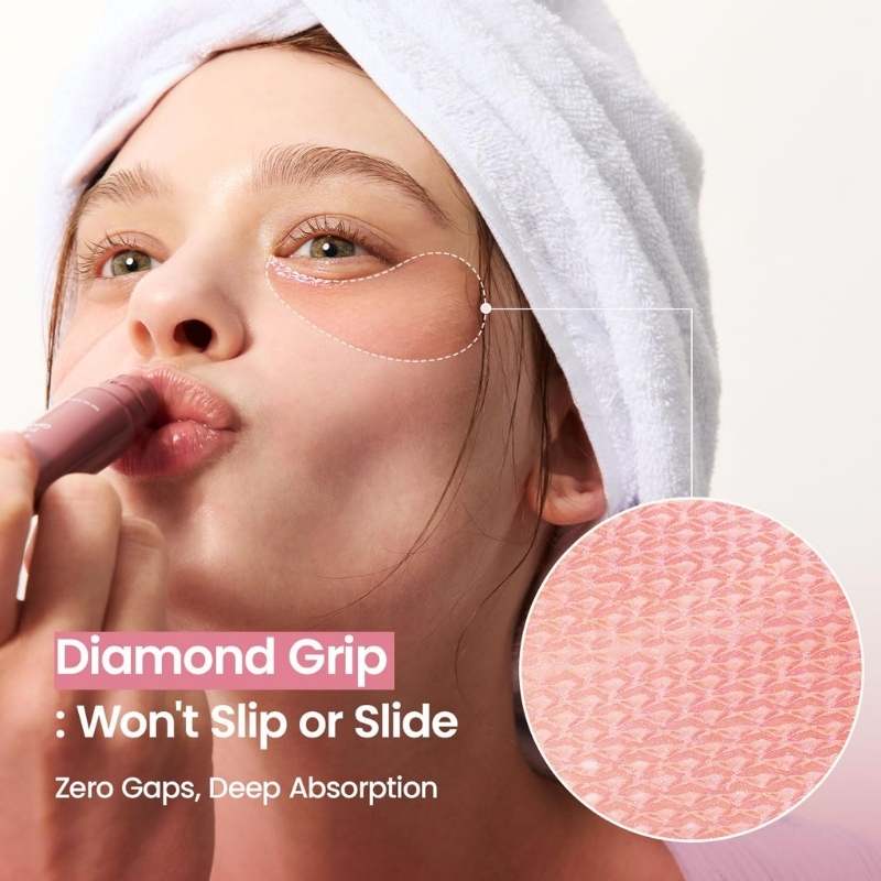 Close-up of a woman with a towel on her head applying lipstick; product text reads 'Diamond Grip: Won't Slip or Slide' with 'Zero Gaps, Deep Absorption' and a pink textured sample.