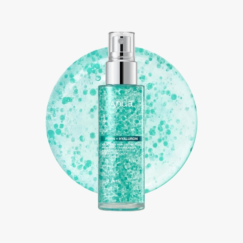 Teal skincare serum bottle with spray nozzle against a dotted teal circle backdrop, brand name Anua visible on the bottle.