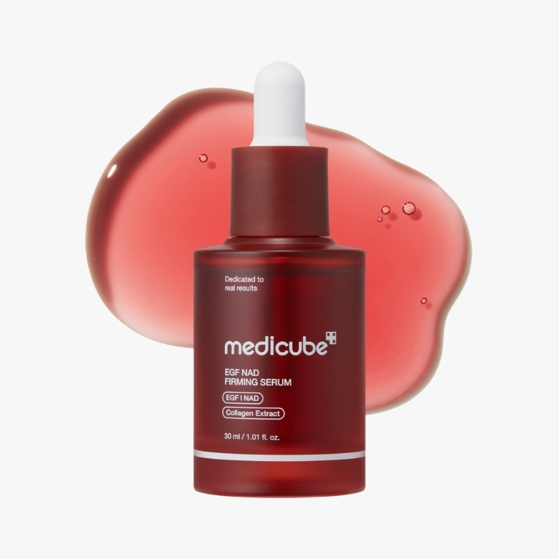 Red dropper serum bottle labeled Medicube EGF NAD Firming Serum with white dropper and pink gel splash in the background, skincare product on white backdrop.