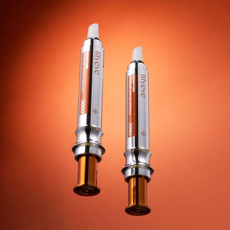Two metallic syringe-like devices with orange labels stand upright on an orange background